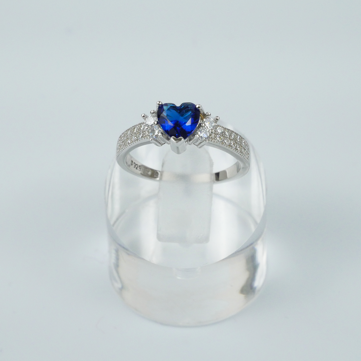 Silver ring with a blue heart-shaped gemstone on a white background