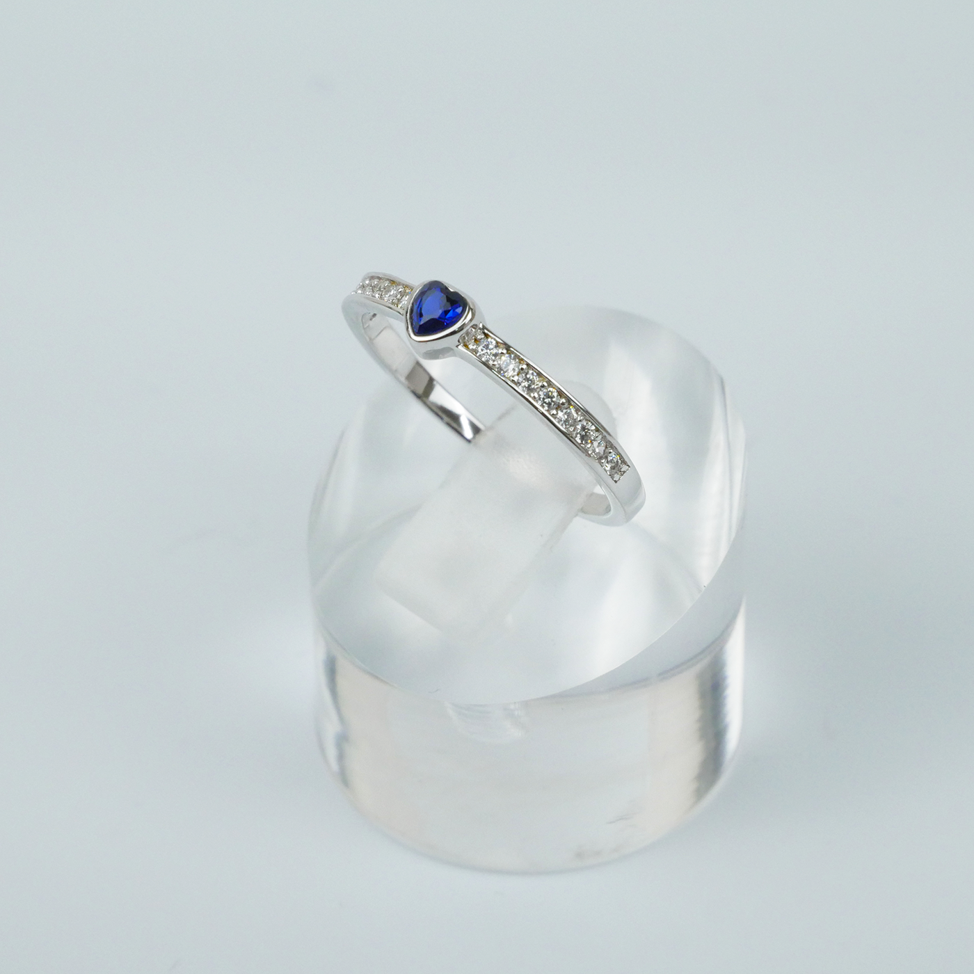 Silver ring with a blue gemstone on a light gray background