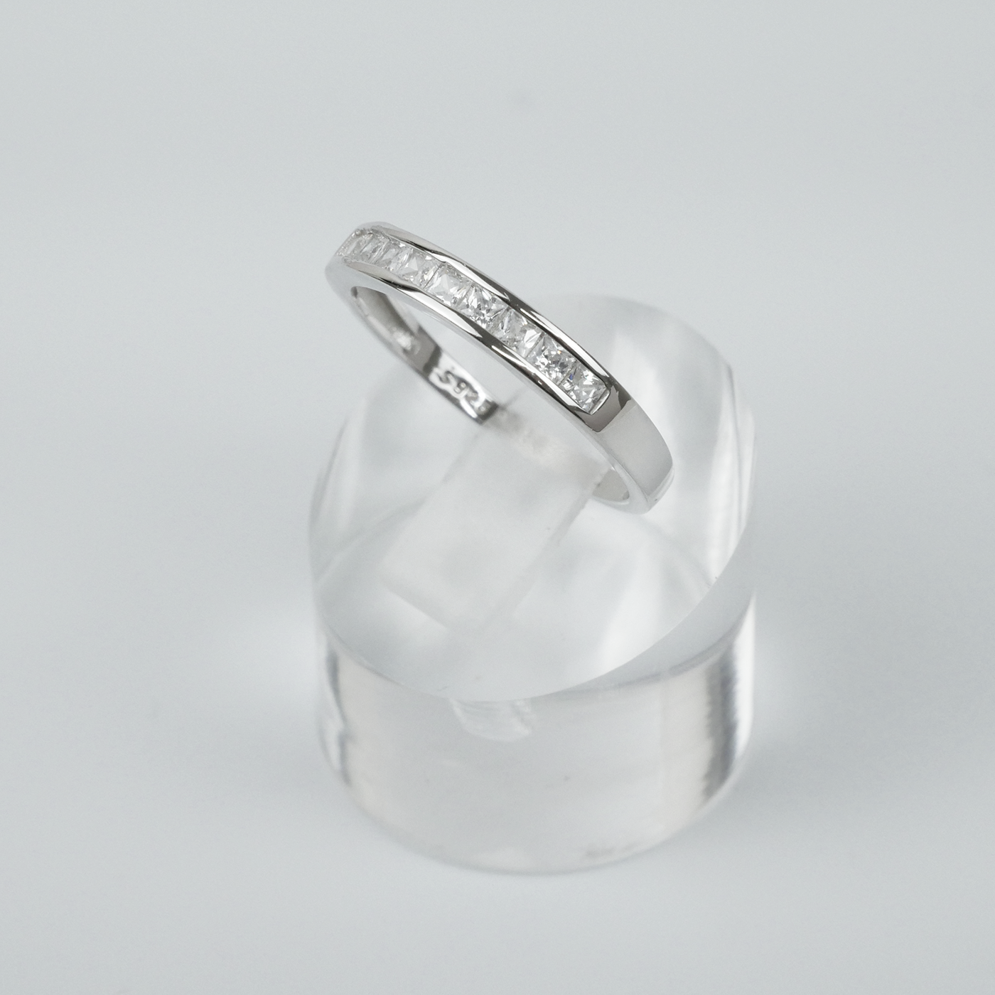 Silver ring with square CZ on a light grey background