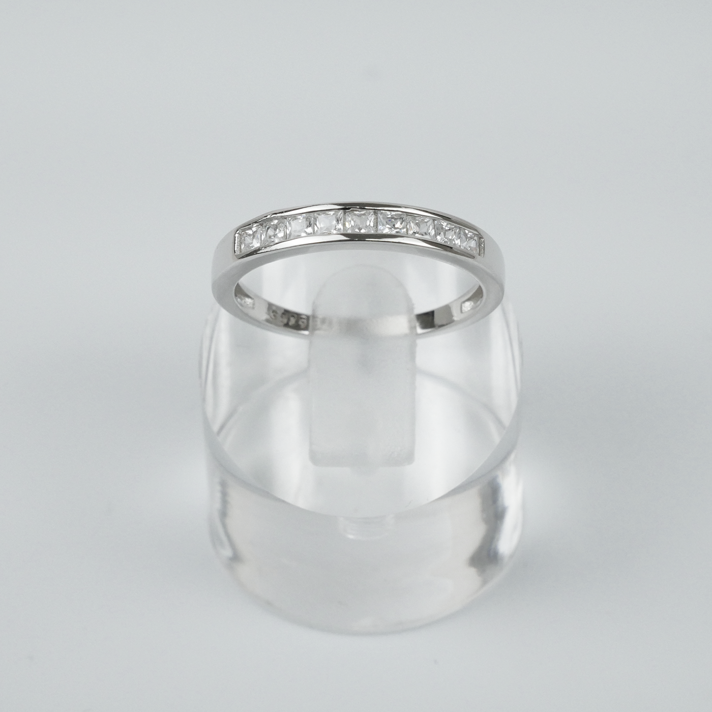 Silver ring with square CZ on a light grey background