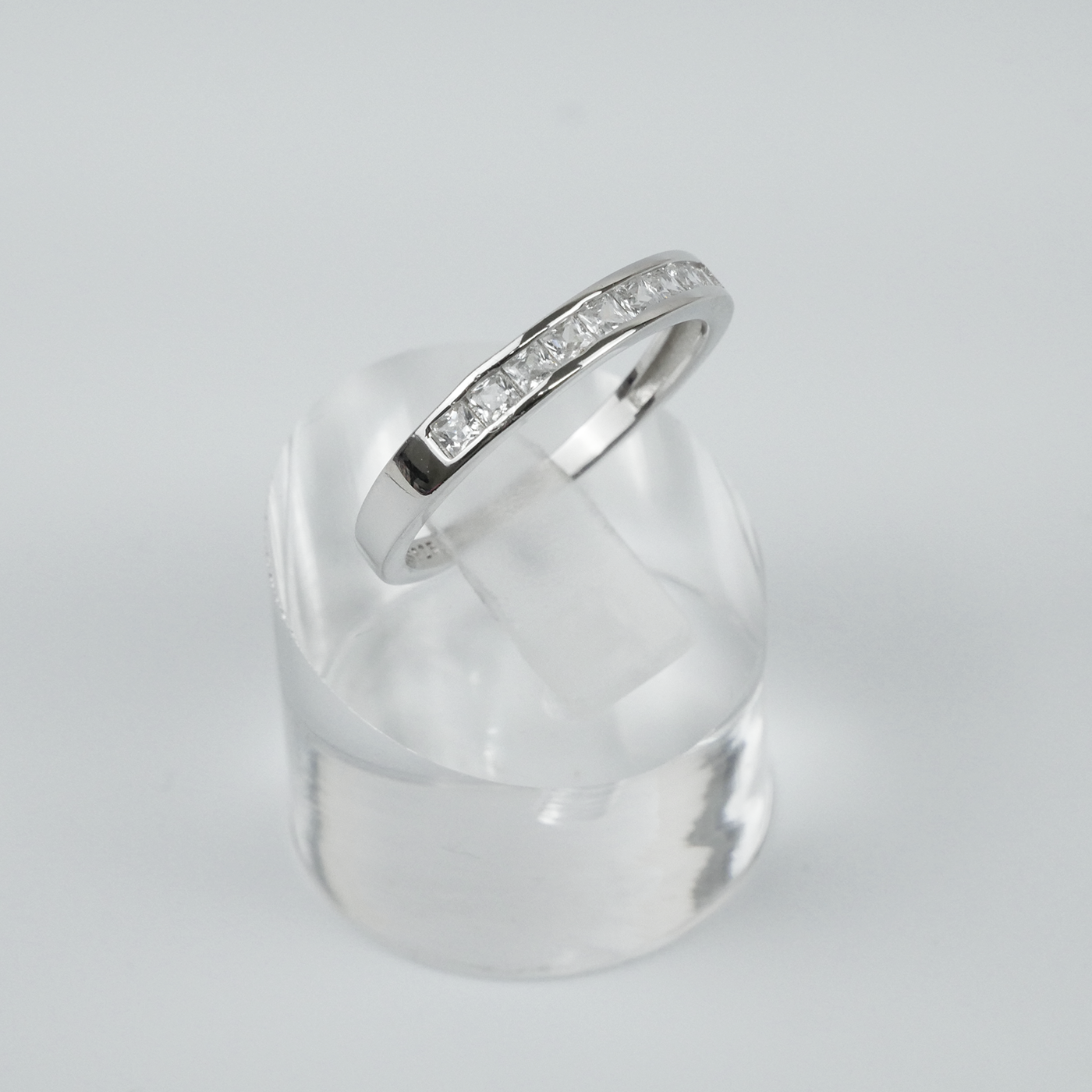 Silver ring with square CZ on a light grey background