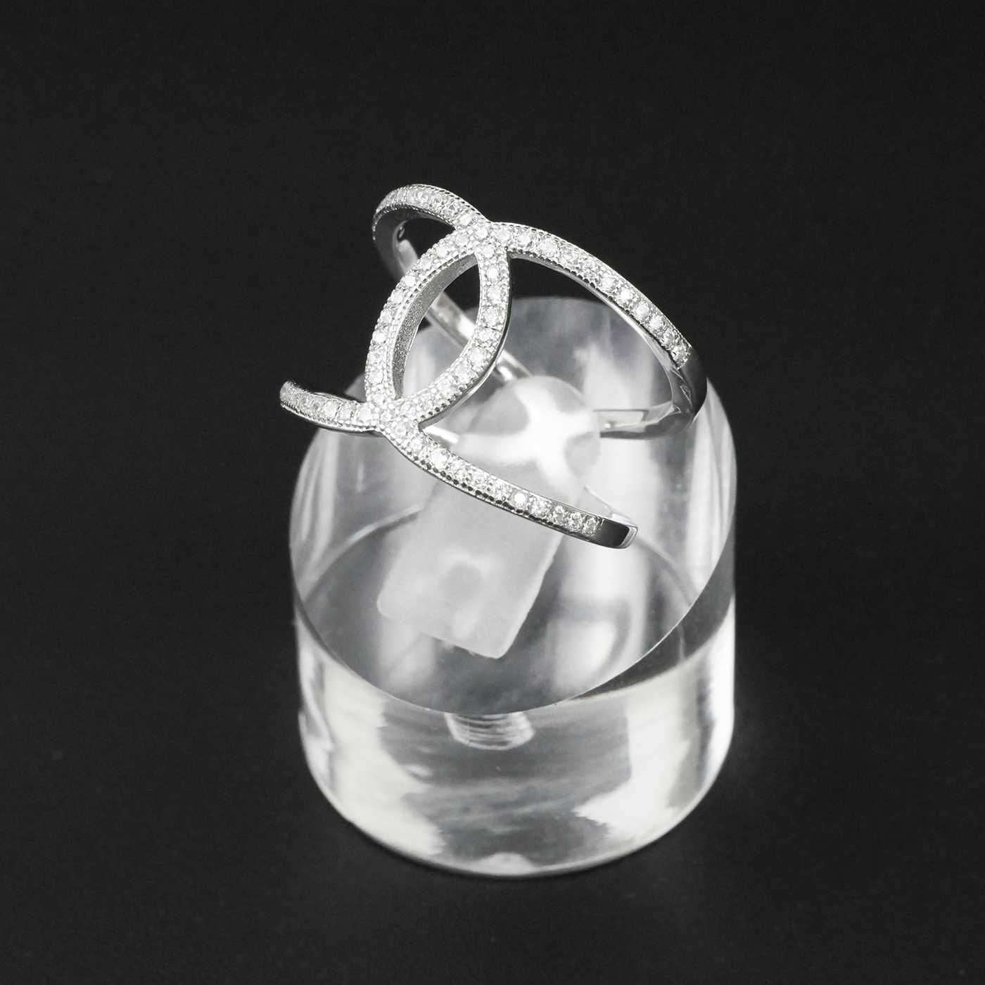 Silver ring with clear gemstones on a black background