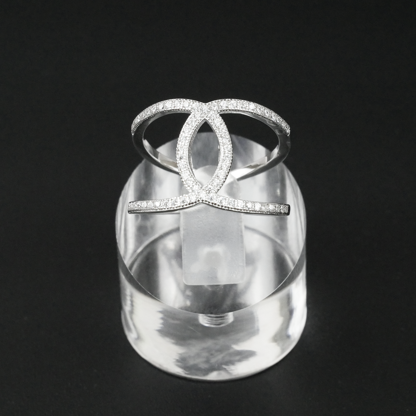 Silver ring with clear gemstones on a black background