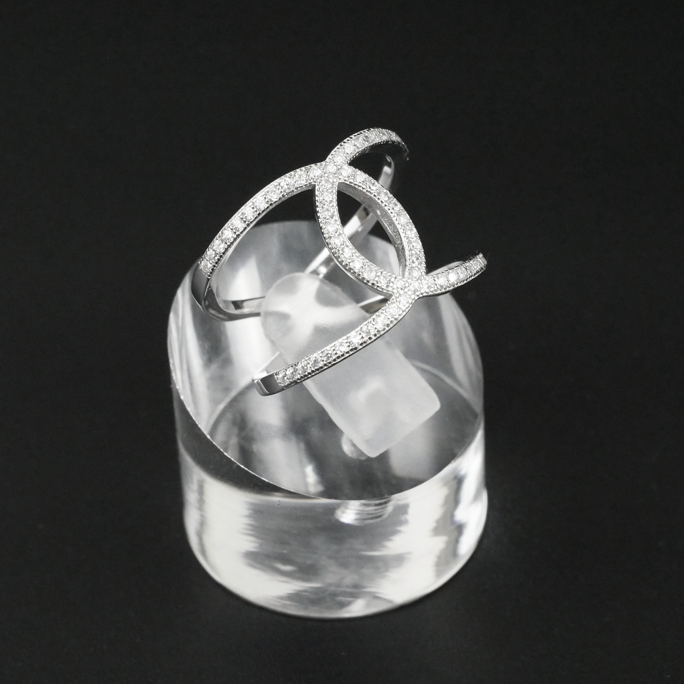 Silver ring with clear gemstones on a black background