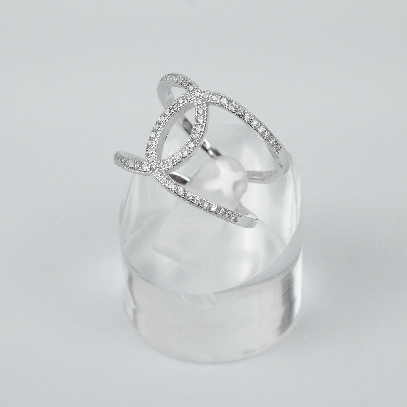 Silver ring with clear gemstones on a light-grey background