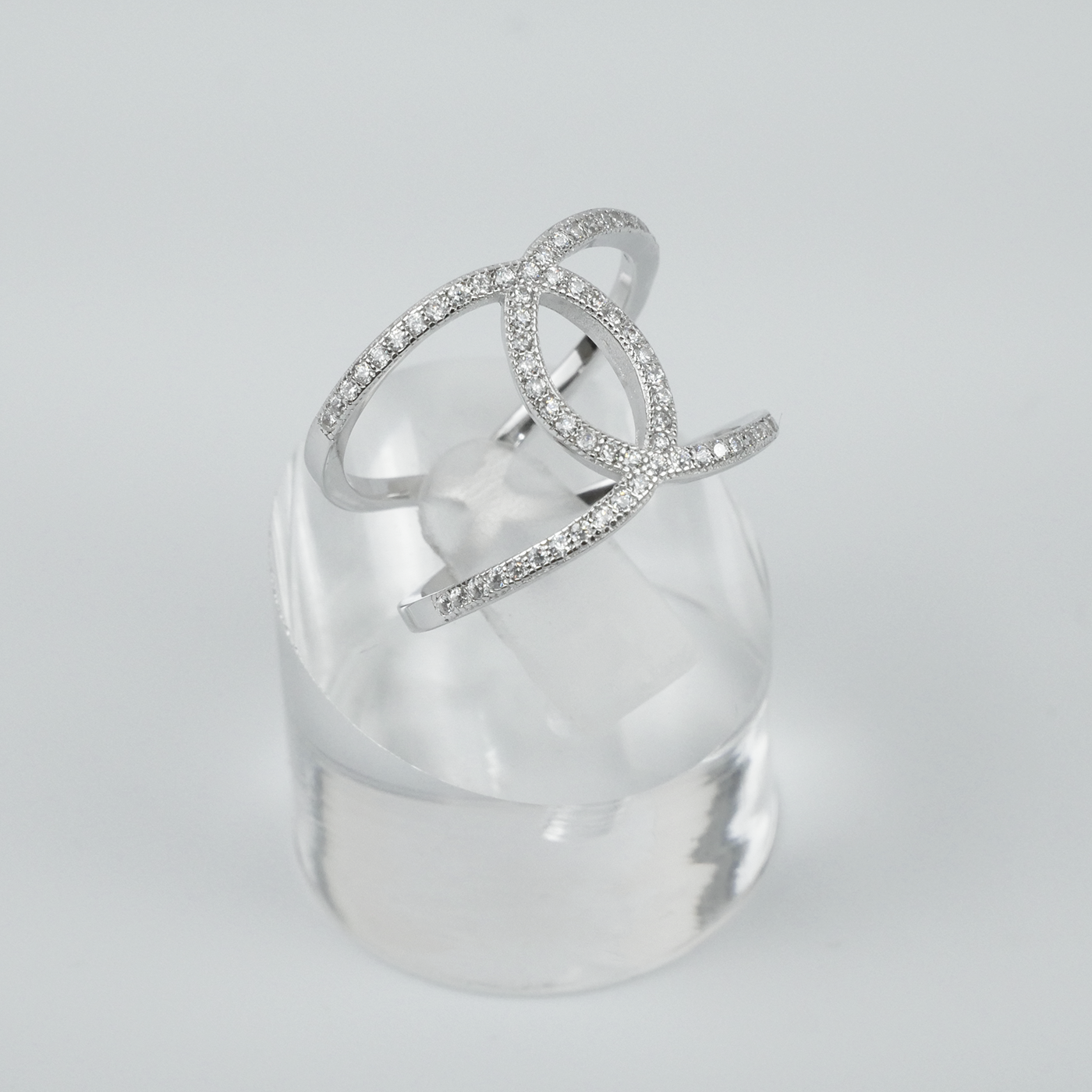 Silver ring with clear gemstones on a light-grey background