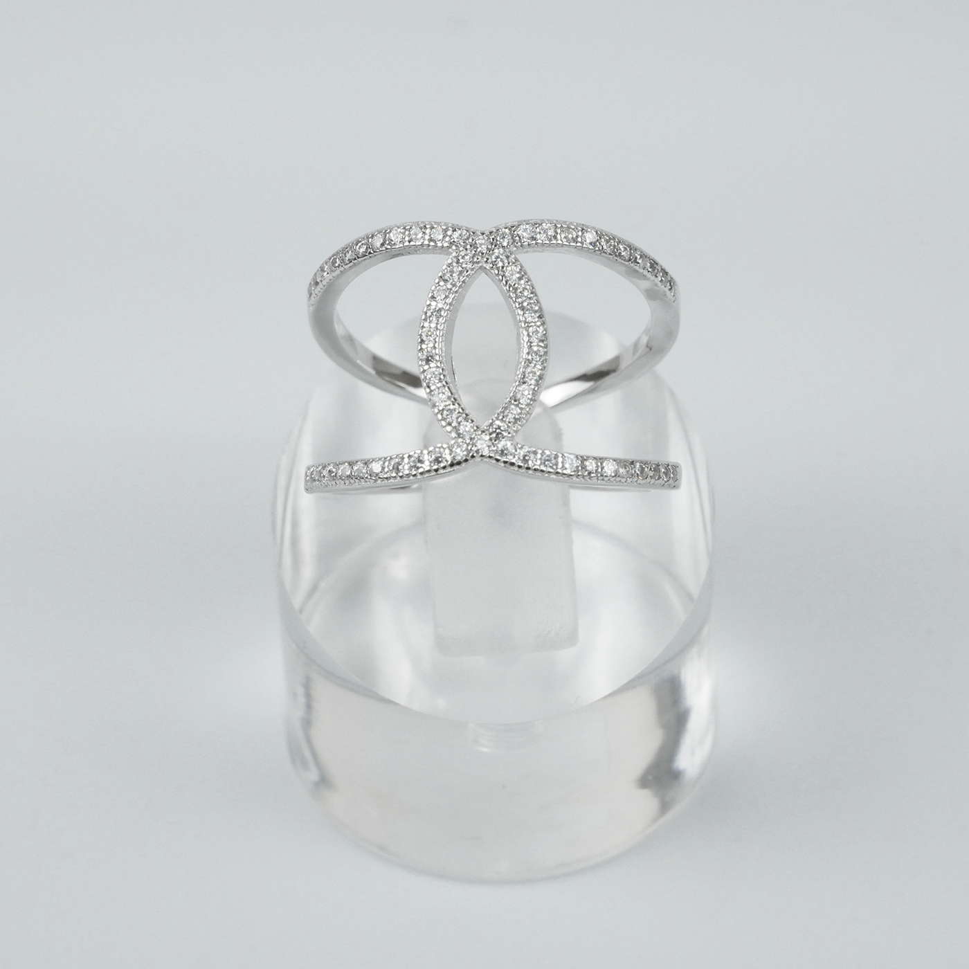 Silver ring with clear gemstones on a light-grey background