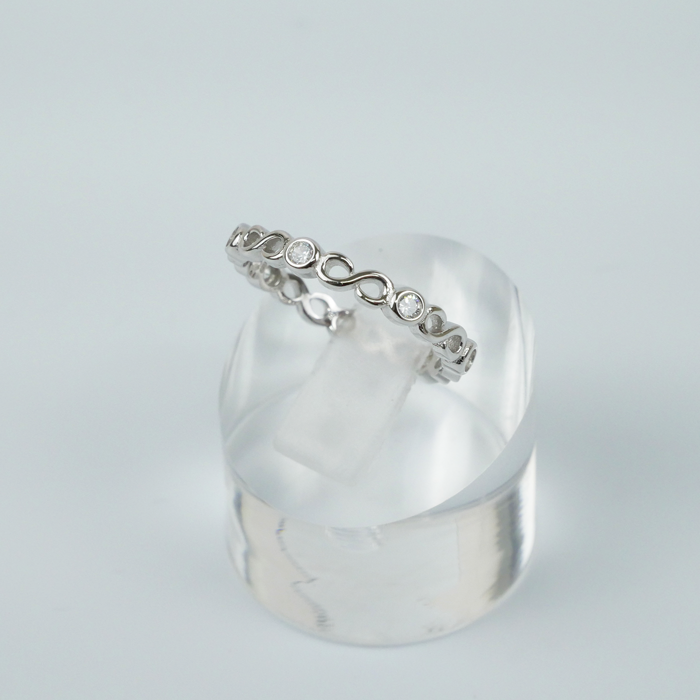 Silver ring with a subtle design on a light gray background