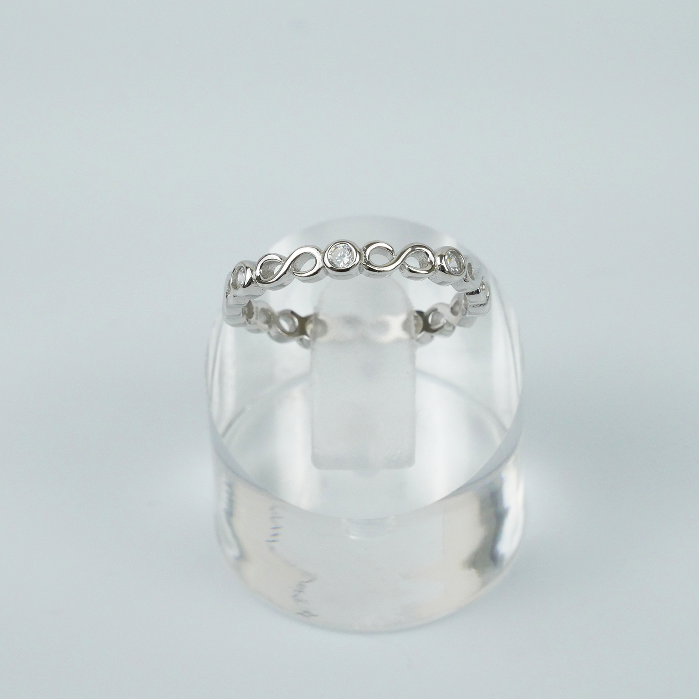 Silver ring with a subtle design on a light gray background