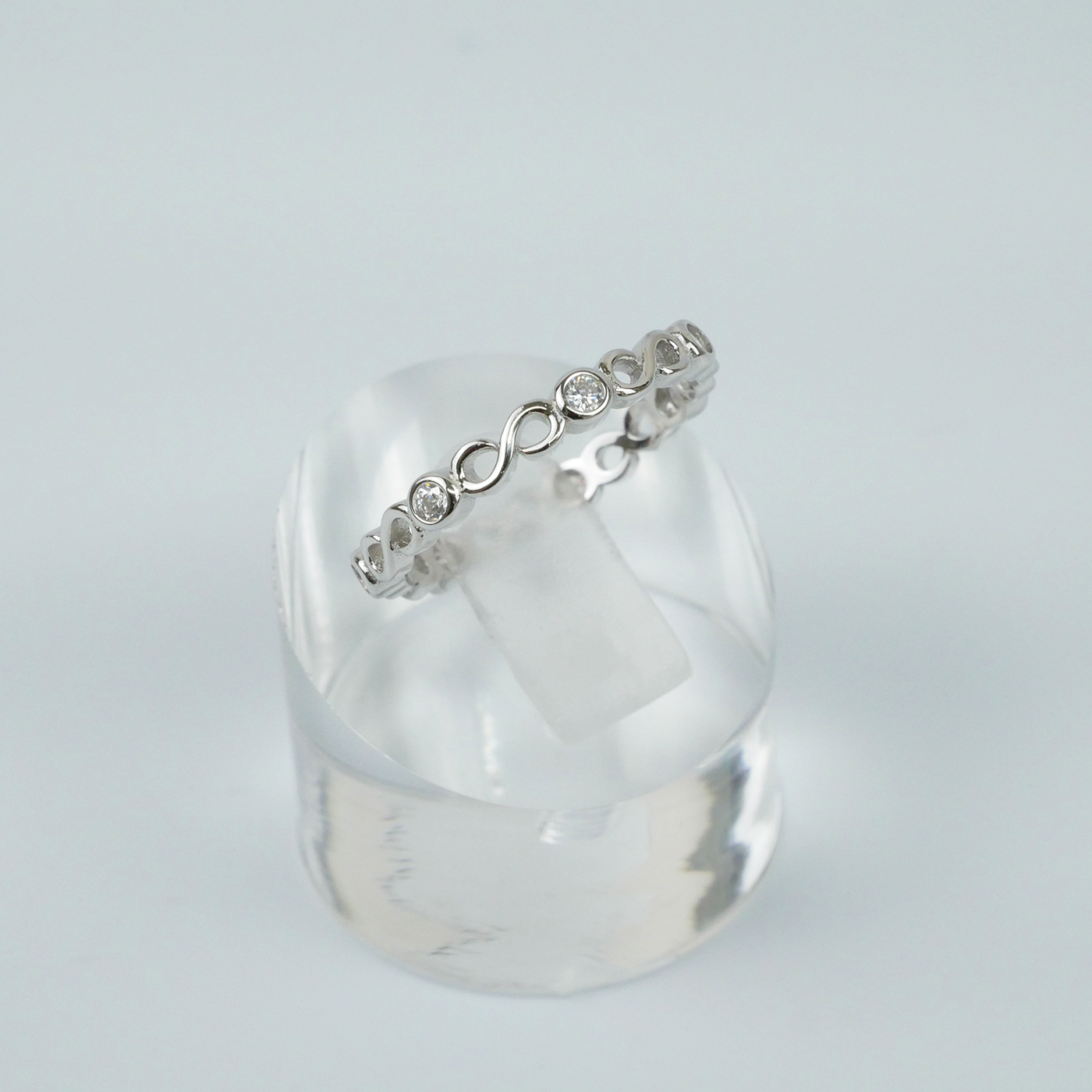 Silver ring with a subtle design on a light gray background