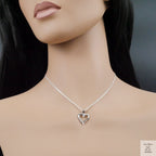 Silver heart-shaped necklace on a mannequin with a dark background