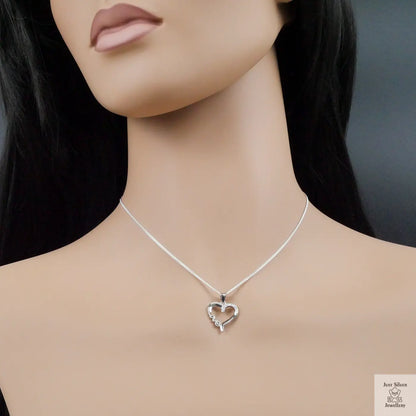 Silver heart-shaped necklace on a mannequin with a dark background