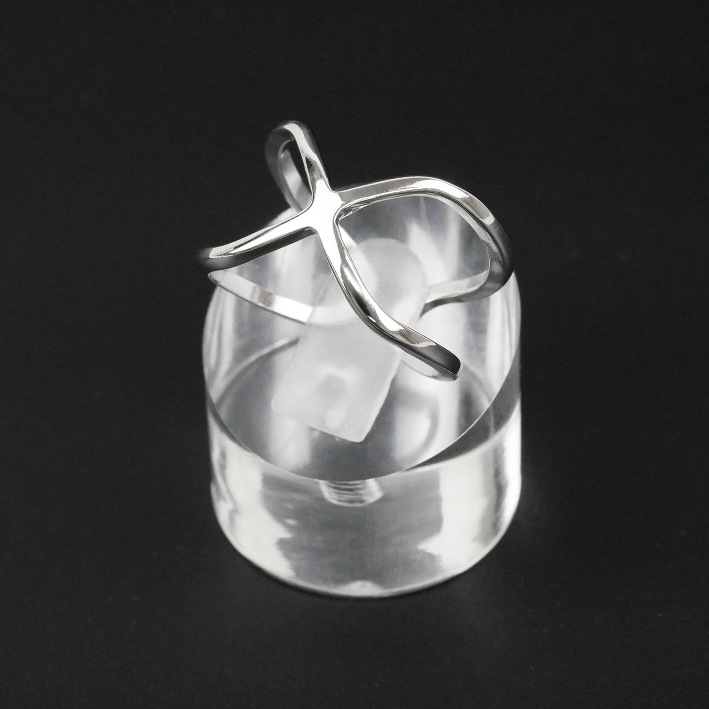 Silver ring with a unique design on a black background