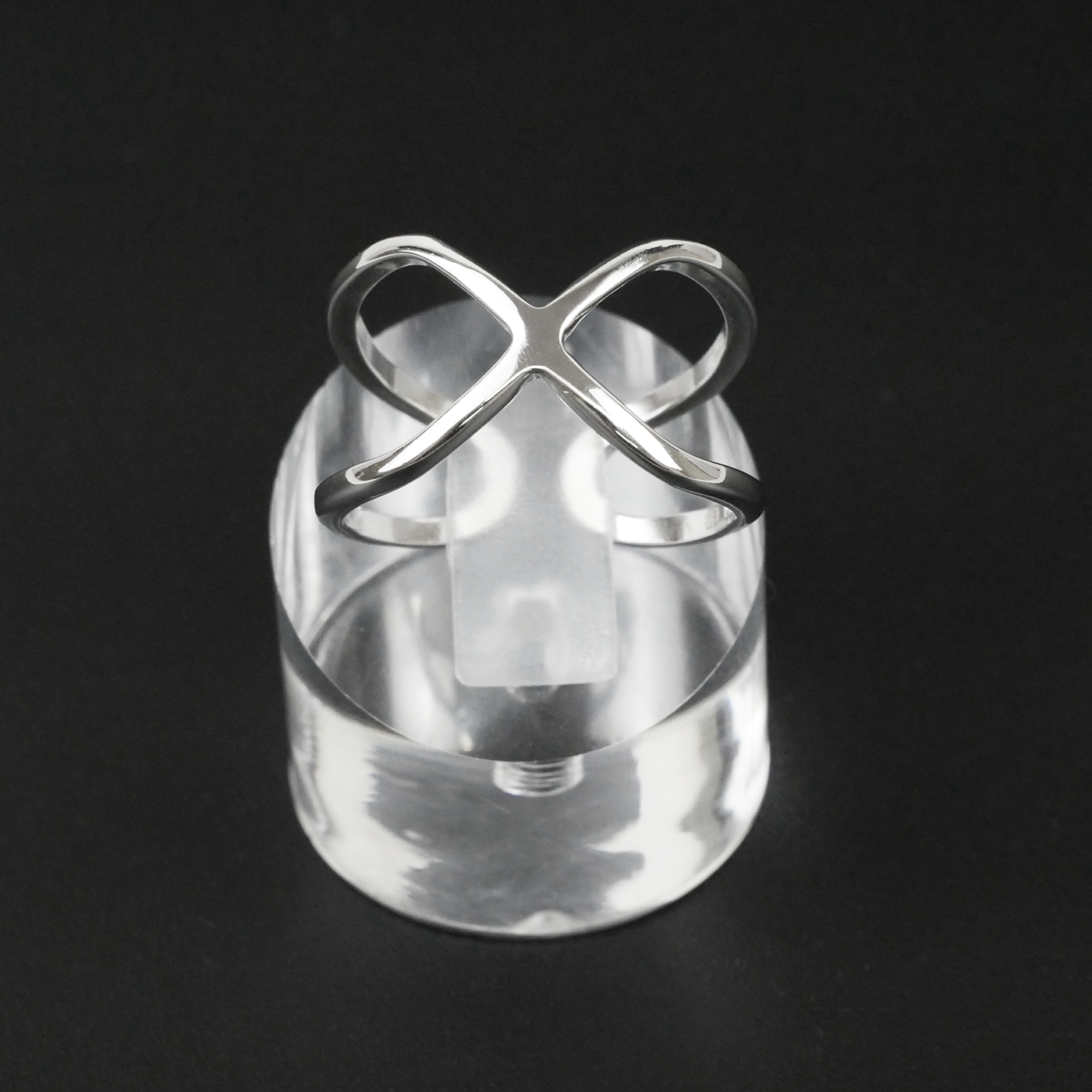 Silver ring with a unique design on a black background