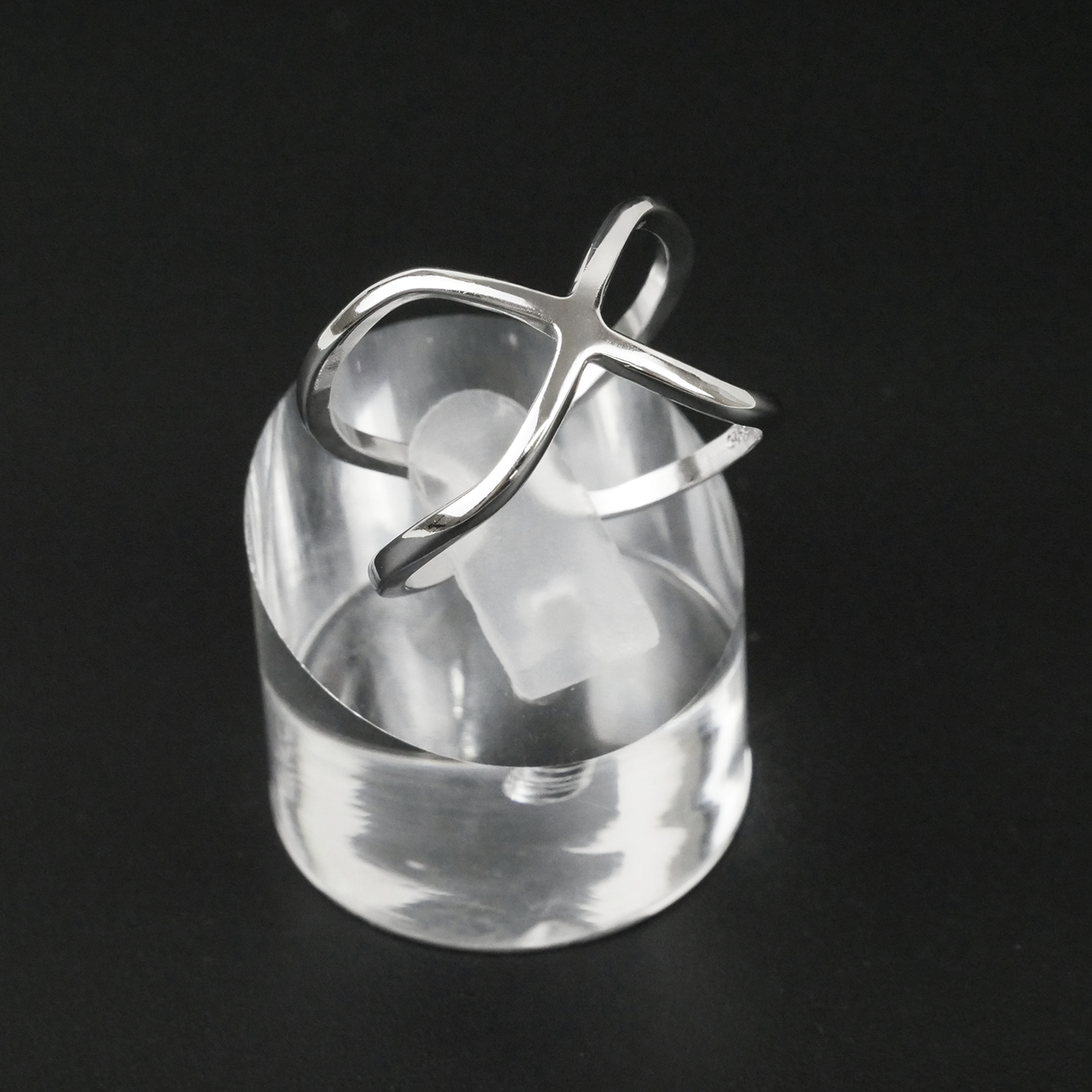 Silver ring with a unique design on a black background