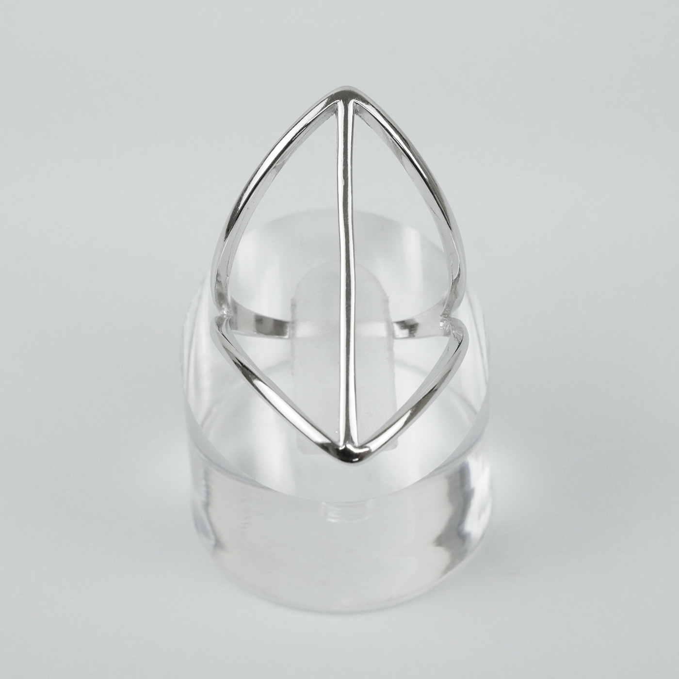 Silver geometric ring on a light gray background