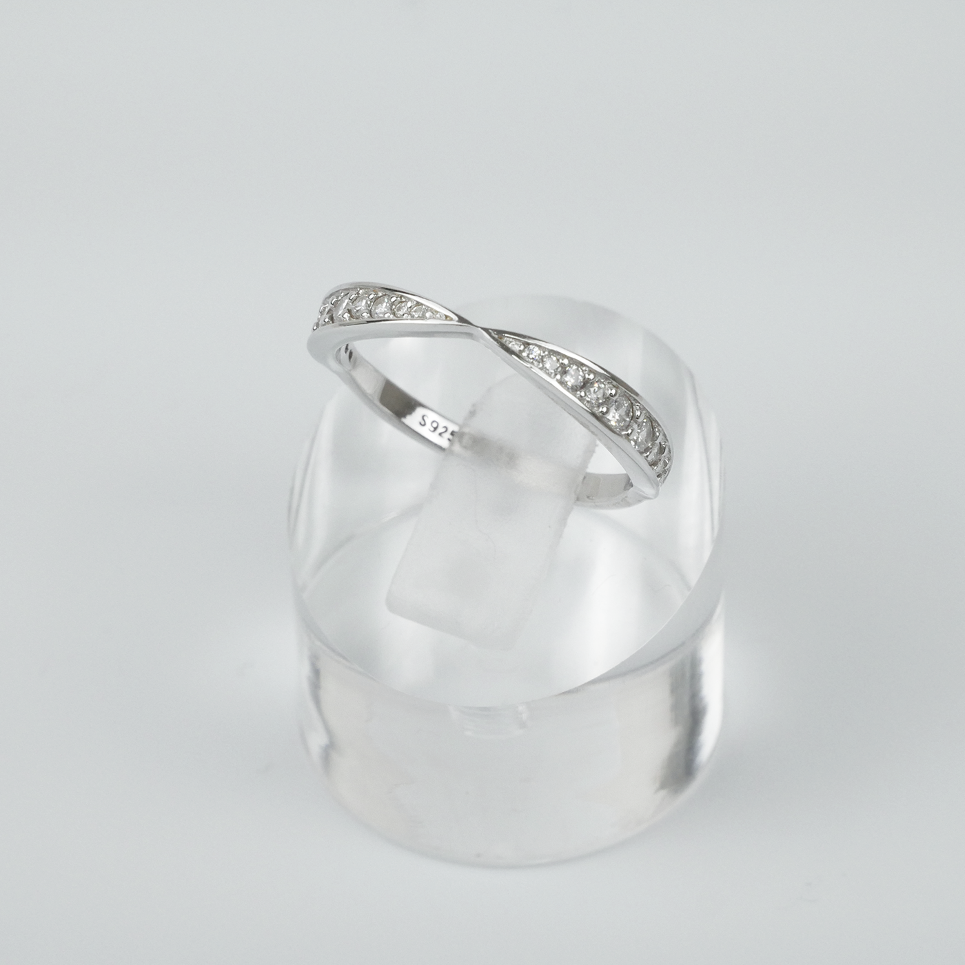 Silver ring with small gemstones on a light gray background