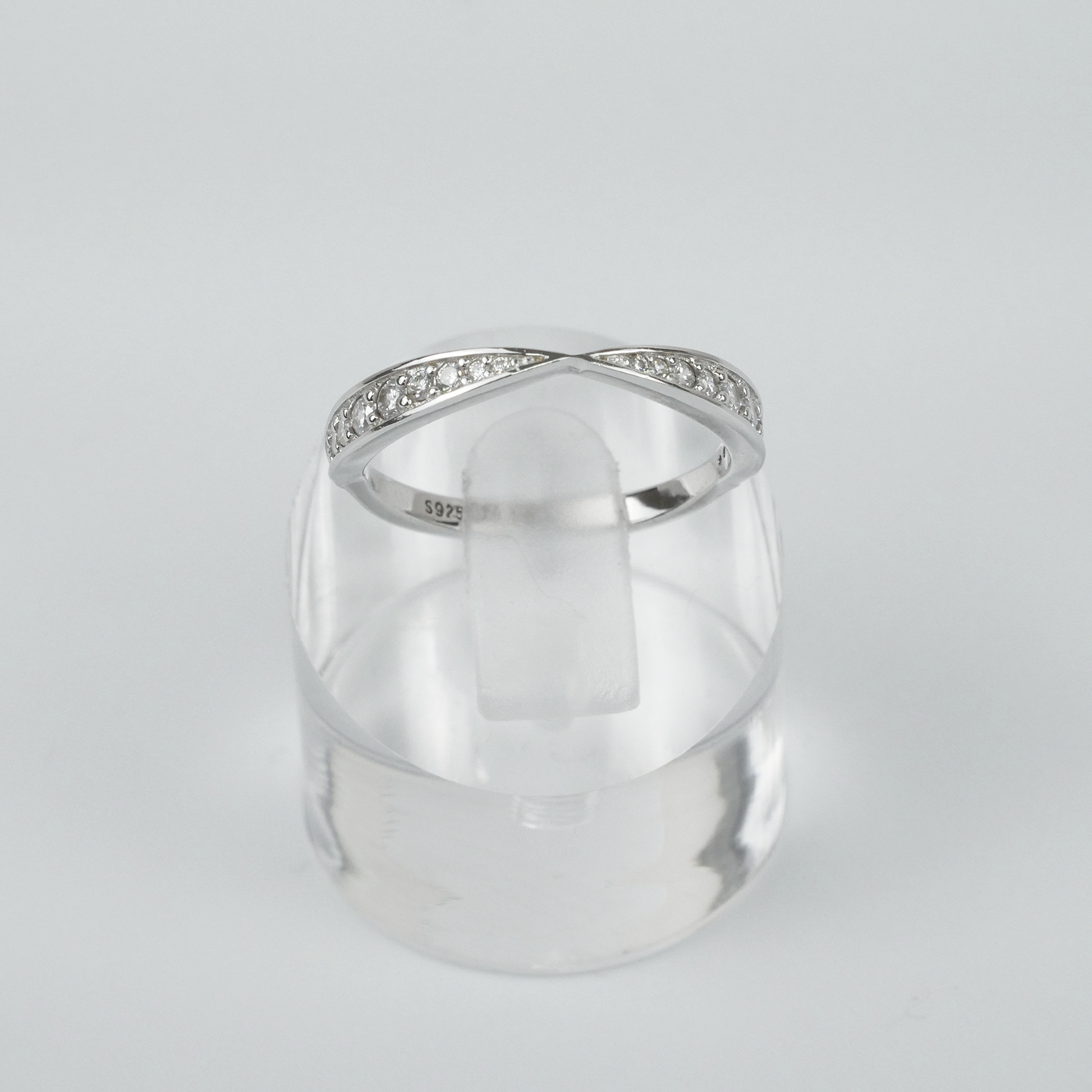 Silver ring with small gemstones on a light gray background