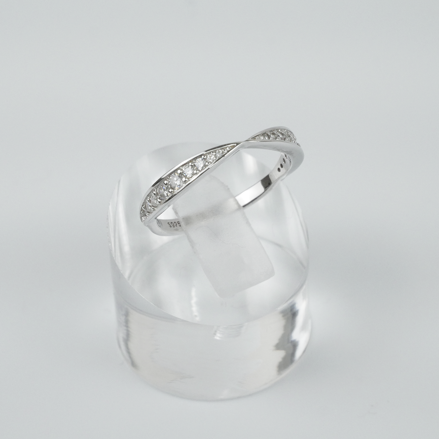 Silver ring with small gemstones on a light gray background