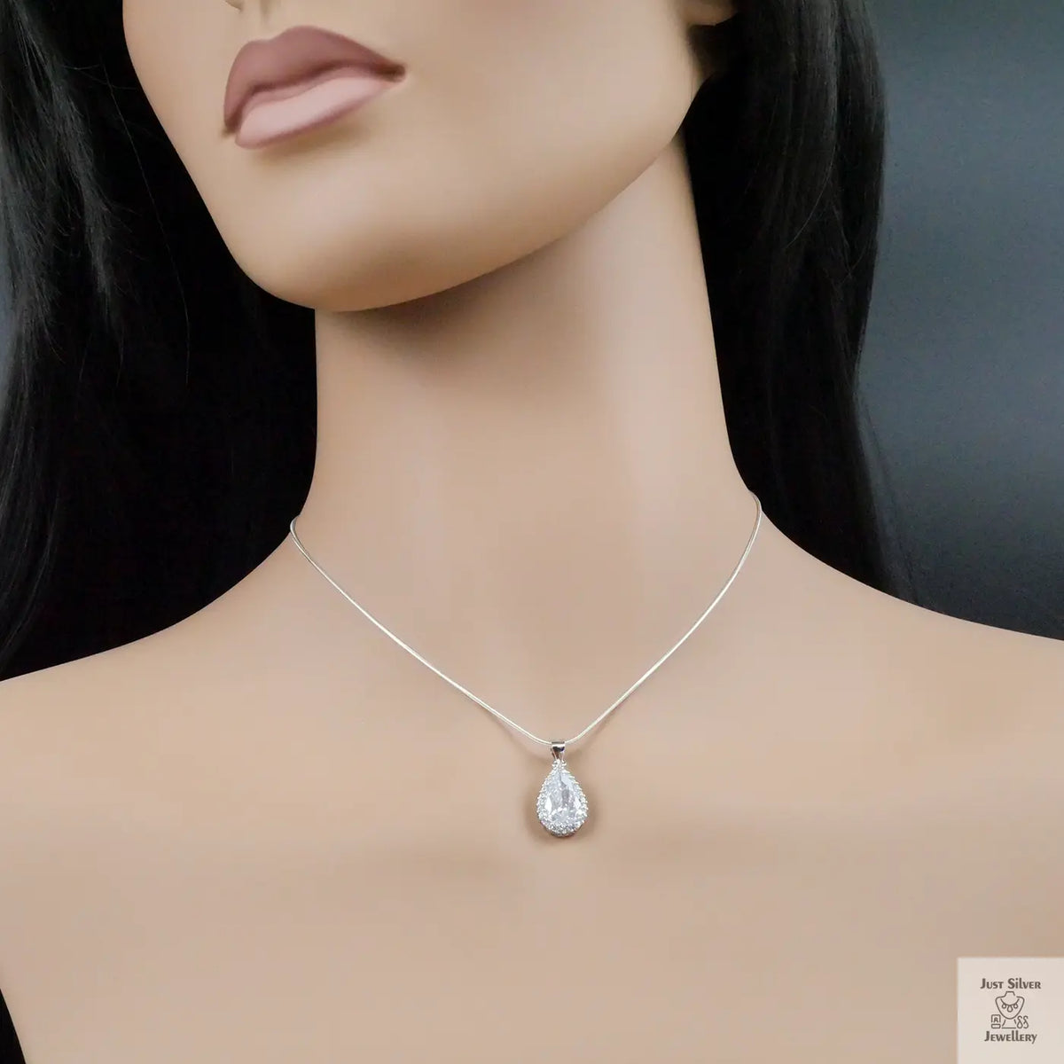 Mannequin wearing a silver teardrop necklace against a dark background