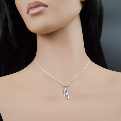 Silver necklace with a pendant on a mannequin against a neutral background
