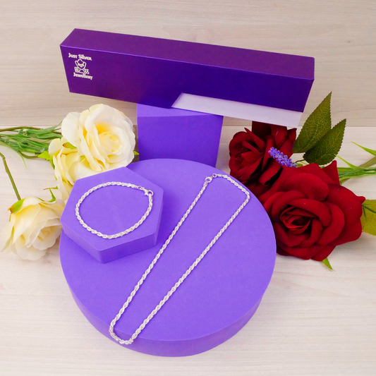 Silver necklace on a purple jewelry box with flowers in the background