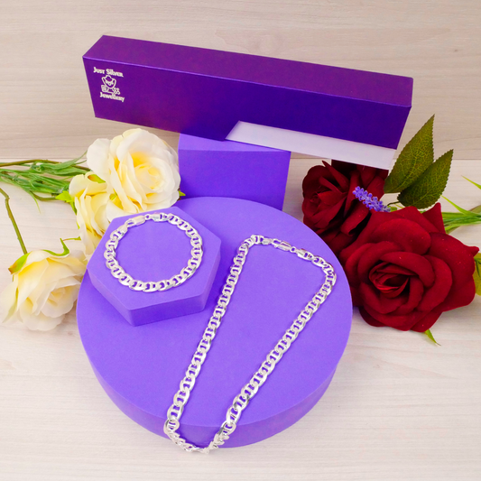 Silver chain necklace on a purple stand with a purple box and flowers in the background