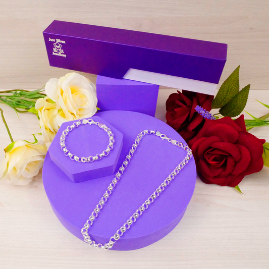 Silver necklace on a purple stand with a purple box and flowers in the background